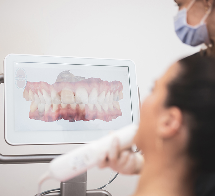 Woman dentist scanning patient's teeth with 3d dental scanner in